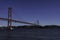 Beautiful view of the Bridge 25th of April over the river Tagus in the heart of Lisbon in Portugal. Small sailing boat and fishing