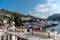 A beautiful view through the bright flowers of petunias to the sea bay with yachts. Turquoise sea against the backdrop