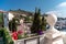 A beautiful view through the bright flowers of petunias to the sea bay with yachts. Turquoise sea against the backdrop