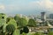 Beautiful view of cactuses with thorns against city and many buildings under cloudy sky, closeup. Space for text