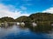 Beautiful view of a calm creek with reflections of blue sky, mountains and trees on water