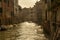 Beautiful view of the canal in Venice with shiny calm waters and small humble buildings of Italy