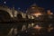 Beautiful view of Castel Sant`Angelo and the bridge at night with reflections on the Tiber river. Rome Italy