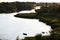 beautiful view of the curved riverbed with empty boats with reeds and trees on the shore at sunse