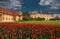 Beautiful view of the Czech castle Lednice, with a cloudy thunderous sky and a lot of red tulips.