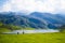 Beautiful view of Ercina Lake in Covadonga Lakes, Asturias, Spain. Green grassland with a couple walking and mountains at the