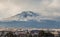 A beautiful view of the eruption of volcano Etna with smoke and snow and Catania city is in the photo in winter in Sicily