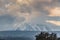 A beautiful view of the eruption of volcano Etna with smoke and snow is in the photo in winter in Sicily