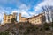 Beautiful view of the famous Hohenschwangau Castle on a sunny day in winter, with blue sky and cloud background, Schwangau,