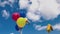 Beautiful view of festive balloons for child developing in  wind against blue sky with white clouds.