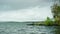 Beautiful view of fisherman on shore with sea on background of horizon with forest. Stock footage. Fishing with