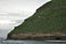 Beautiful view of a flock of puffins flying over the sea near the hill in Iceland