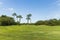 Beautiful view of golf field and green trees on blue sky background. Tropical natural landscape backgrounds.