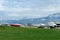 Beautiful view of green lawn in front of the embankment with boats and yacht on land on trailer against the backdrop of snow-c