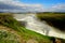 Beautiful view of Gullfoss waterfalls of Iceland with mist and rainbow above the tourists in the summer