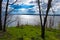 Beautiful View from the high bank of the river to the radiance of water in the rays of the rising spring sun