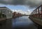 A beautiful view of the houses of modern architecture on the banks of the canal in the Dutch city of Vlaardingen on a cloudy day