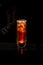 beautiful view of illuminated glass with alcoholic drink standing on bar counter in dark bar