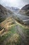 Beautiful view on impressive gorge in Caucasus mountains. Monument in form of Cross and path to it