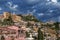 Beautiful view of the inhabited center of the hill town of Taormina, Messina, Sicily, Italy, against a dramatic sky