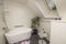 Beautiful view of interior of bathroom in the house. Roof window with flower, coffee table and carafe of water