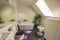 Beautiful view of interior of bathroom in the house. Roof window with flower, coffee table and carafe of water