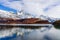 Beautiful view of lake Capri with Fitz roy mountains with white snow peak and colorful red leaves tree in sunny blue sky day in