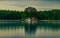 Beautiful view of a lake and reflection of small house and forest in it