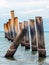 Beautiful view of leaning pillars of the old pier. Slanted concrete pole beach. Abandoned fishing pier pillar by the sea. Many of