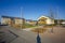 Beautiful view of leaving area. House with solar panels and school building with outdoor activity children place.