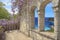 Beautiful view of the loggia and on the sea, a loggia of natural stone the masonry with arched windows ,  blossoming Wisteria on