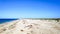 Beautiful view on long sand seaside ocean bank, shore at sunny summer day with blue sky, tropical vacation. Panoramic