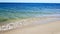 Beautiful view on long sand seaside ocean bank, shore at sunny summer day with blue sky, tropical vacation. Panoramic