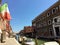 A beautiful view looking down a busy canal in Murano, Italy.  Boats are driving down the canal and tourists are visiting the shops