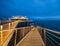 Beautiful view of a modern metallic pier covered in bright lights gleaming under the night sky