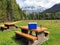 A beautiful view with the mountains in the background of a lovely picnic bench with a cooler and water bottle on top.