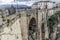 Beautiful view of the New Bridge, Puente Nuevo in Ronda with its stone arches and its snowy mountains in the background