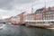 Beautiful view of Nyhavn canal with colorful buildings at cloudy day. Harbour and the lined by brightly coloured townhouses and ba