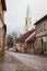 Beautiful view of old countryside brick road street with white church tower in the backgorund