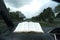 Beautiful view of open Holy Bible in Psalm 91. Windshield with raindrops. Blurred background with expressway and cars.