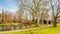 Beautiful view of a park with a pond, a path, trees and green grass and a church in the background