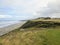 A beautiful view of a parkland area with a par 4 golf hole in Bandon, Oregon, with the ocean in the background and yellow heather