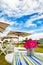 Beautiful view of pink flowers in a basket on the table with umbrellas in the background