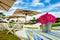 Beautiful view of pink flowers in a basket on the table with umbrellas in the background