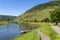 Beautiful view of a river flowing between grape hills in western Germany, a motorboat visible.