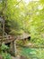 Beautiful view of river rock bed with wooden bridge across the riveri in the forest at nature park Kamacnik in Croatia