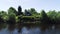 Beautiful view from river to shore with village house and boat in summer. Shot. Drone view of beautiful green beach with