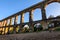 Beautiful view of roman Aqueduct Pont del Diable in Tarragona at sunset with people jogging in front of it