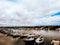 Beautiful view of the rows of fishing boats on the river gleaming under the cloudy sky