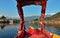 Beautiful view of Shikara boat ride on dal lake with houseboats and mountain background at Srinagar, Kashmir, India.